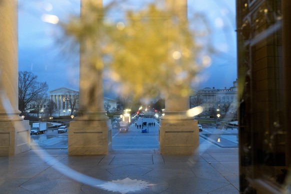 Past glass that was impacted during the riot at the Capitol, National Guard troops can be seen on the grounds, Saturday, Jan. 16, 2021, in Washington as security is increased ahead of the inauguration ...