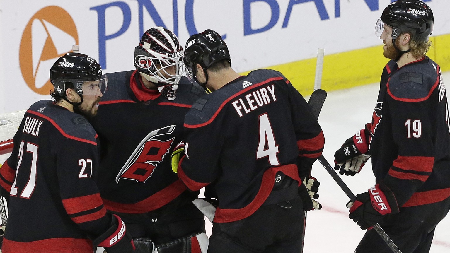 Carolina Hurricanes goalie Curtis McElhinney is congratulated by Justin Faulk (27), Haydn Fleury (4) and Dougie Hamilton (19) following the Hurricanes&#039; 5-2 win over the New York Islanders in Game ...
