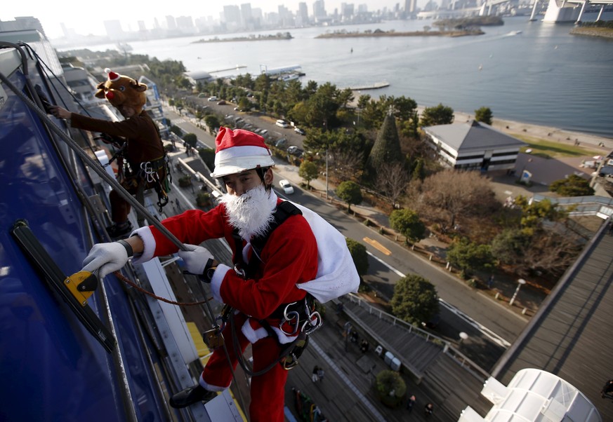 Fensterputzer im Weihnachtskostüm in Tokio.