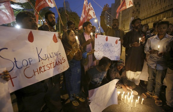 Pakistani Christians hold candles during a demonstration to condemn the Quetta&#039;s suicide attack on a church, in Karachi, Pakistan, Sunday, Dec. 17, 2017. Two suicide bombers attacked the church i ...