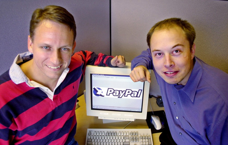 FILE--PayPal Chief Executive Officer Peter Thiel, left, and founder Elon Musk, right, pose with the PayPal logo at corporate headquarters in Palo Alto, Calif., on Oct. 20, 2000. Online auction giant e ...