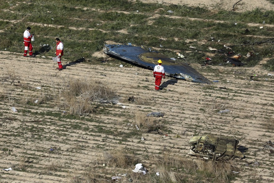 In this Wednesday, Jan. 8, 2020 photo, rescue workers search the scene where a Ukrainian plane crashed in Shahedshahr, southwest of the capital Tehran, Iran. Iran on Friday denied Western allegations  ...