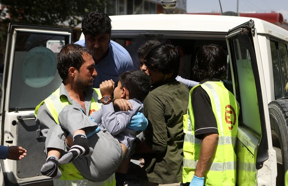 epa07686481 An Afghan health worker carries a wounded school student after a car bomb blast targeted a governmental institution in downtown Kabul, Afghanistan, 01 July 2019. According to reports, doze ...