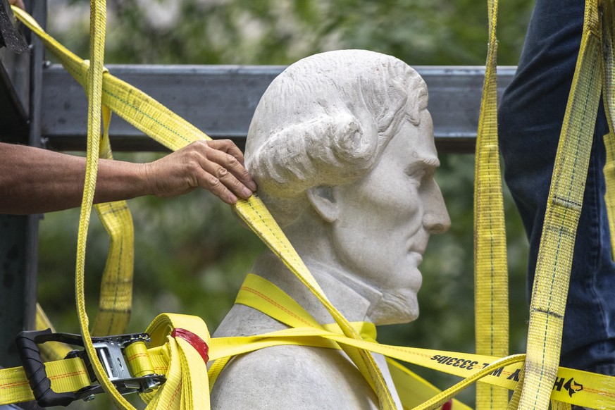 Workers secure a statue of Jefferson Davis to a trailer after removing it from the the Kentucky state Capitol in Frankfort, Ky., on Saturday, June 13, 2020. (Ryan C. Hermens/Lexington Herald-Leader vi ...