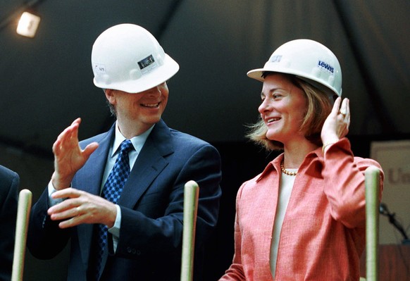 FILE - In this May 4, 2001, file photo, Microsoft Chairman Bill Gates contends with an ill-fitting hard hat while his wife, Melinda Gates, looks on in Seattle at the groundbreaking of the University o ...