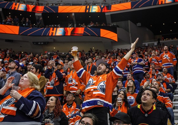 FILE - In this Oct. 2, 2019, file photo, Edmonton Oilers fans celebrate a goal against the Vancouver Canucks during the first period of an NHL hockey game in Edmonton, Alberta. Many NHL issues are sim ...