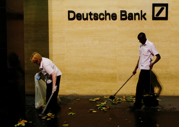 Workers sweep leaves outside Deutsche Bank offices in London, Britain December 5, 2013. REUTERS/Luke MacGregor/File Photo