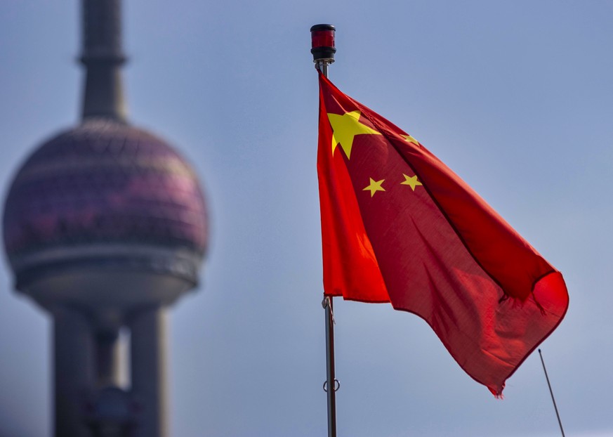 epa08572045 The Chinese flag is seen in front of the Shanghai Oriental Pearl TV Tower landmark in Shanghai, China, 29 July 2020. The World Bank reports that despite the measures taken to contain the e ...