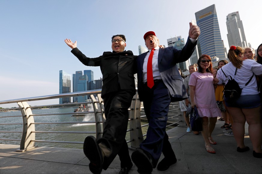 epa06792892 Kim Jong-Un impersonator Howard X (L) and Donald Trump impersonator Dennis Alan (2-L) pose for a photo at the Merlion Park in Singapore, 08 June 2018. US President Donald J. Trump and Nort ...