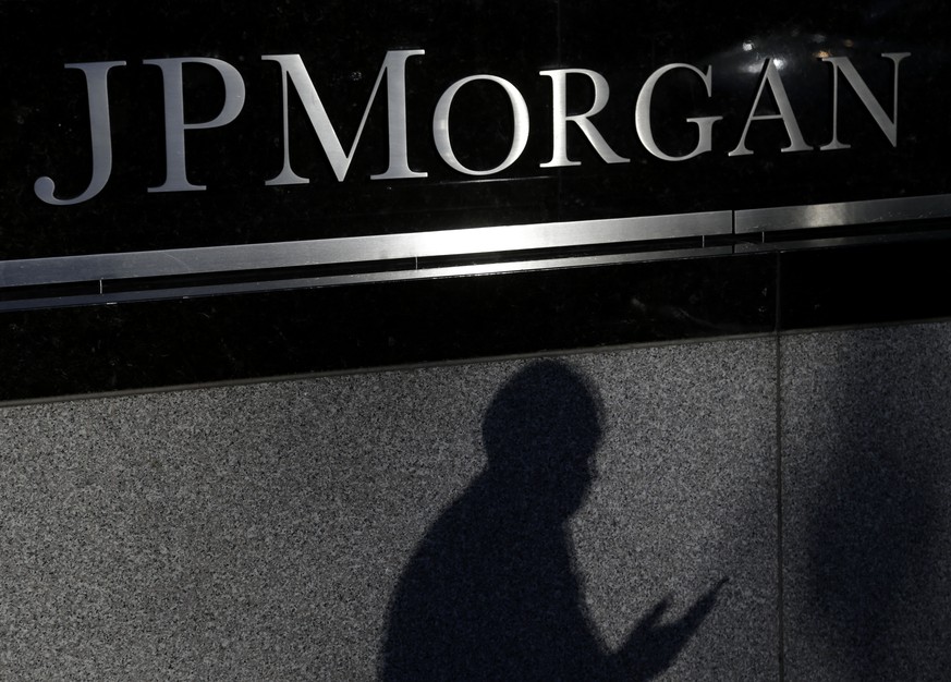 FILE - In this Nov. 19, 2013, file photo, the shadows of a pedestrian is cast under a sign in front of JPMorgan Chase &amp; Co. headquarters in New York. JPMorgan Chase on Monday, Nov. 3, 2014 said th ...