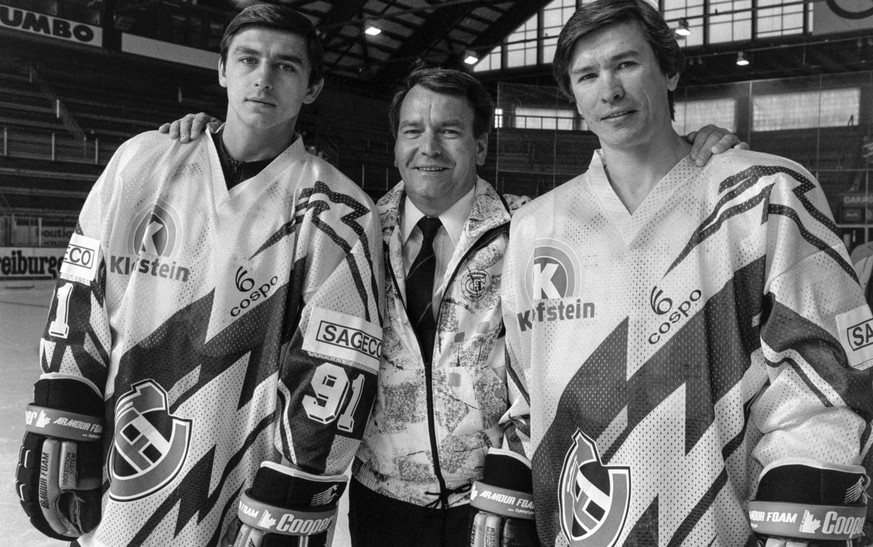 Jean Martinet, Mitte, Praesident des Eishockeyclubs HC Fribourg-Gotteron, mit den zwei Russen im Club Slawa Bykow, rechts, und Andrei Chomutow, links, aufgenommen im Oktober 1990. (KEYSTONE/Str)