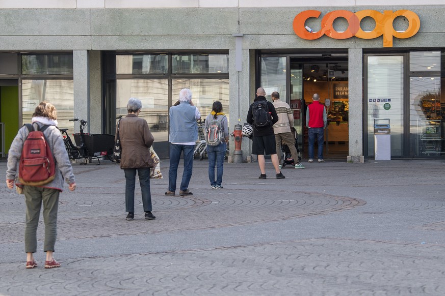 Des clients d&#039;un magasin d&#039;alimentations (Coop) font la queue a l&#039;exterieur avec une distance de 2 metres entre chaque personne avant de pouvoir faire leurs courses, ce mercredi 8 avril ...