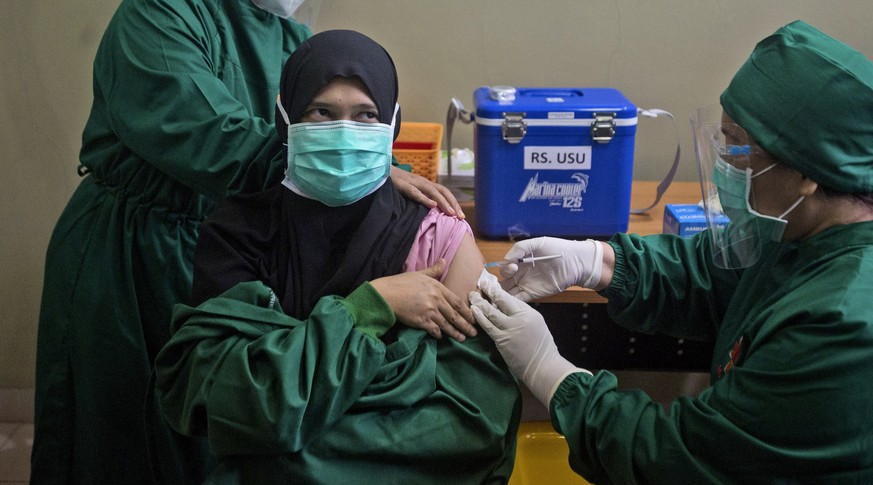 Dr. Lili Rahmawaty gives a shot of COVID-19 vaccine to a colleague at the North Sumatra University Hospital in Medan, North Sumatra, Indonesia, Wednesday, Jan. 20, 2021. The world&#039;s fourth most p ...