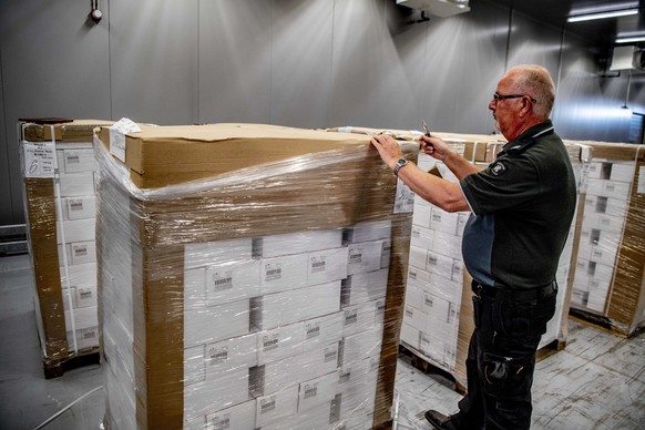 epa07398398 An officer of the customs authorities in the port of Rotterdam presents a box with bottles of vodka, in Rotterdam, The Netherlands, 26 February 2019, after a container with 90,000 bottles  ...