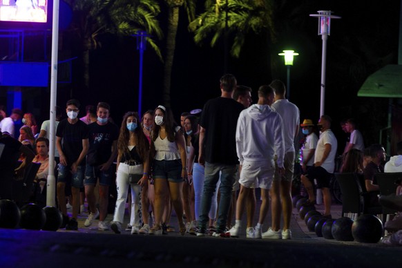 Tourists walk at the street as others stand in a terrace at the resort of Magaluf on the Spanish Balearic island of Mallorca, Spain, Thursday, July 16, 2020. Authorities in Spain&#039;s Balearic Islan ...