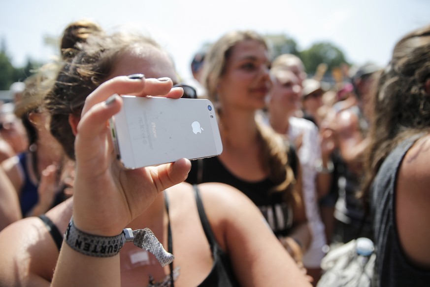 A fan films the performance of british singer-songwriter George Ezra with an iphone at the Gurten music open air festival in Bern, Switzerland, Sunday, July 19, 2015. (KEYSTONE/Peter Klaunzer)