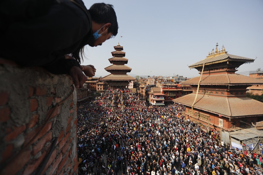 People watch devotees pulling a chariot in Biska Jatra Festival in Bhaktapur, Nepal, Saturday, April 10, 2021. During this festival, also regarded as Nepalese New Year, images of Hindu god Bhairava an ...