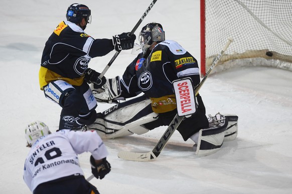 Zug&#039;s player Sven Senteler, front, scores the 2-2 goal against Ambri&#039;s goalkeeper Benjamin Conz, right, during the regular season game of the National League Swiss Championship 2018/19 betwe ...