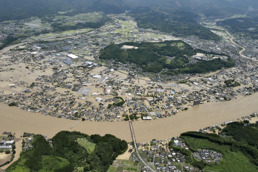Areas are inundated in muddy waters that gushed out from the Kuma River in Hitoyoshi, Kumamoto prefecture, southwestern Japan, Saturday, July 4, 2020. Heavy rain triggered flooding and mudslides on Sa ...