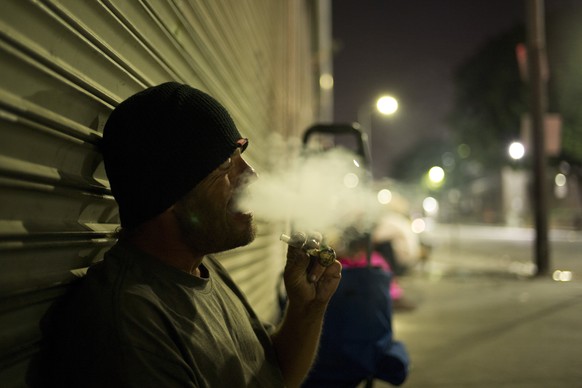 D. J. Meek, a 40-year-old homeless drug addict, smokes crystal meth Friday, Sept. 8, 2017, in the Skid Row area of downtown Los Angeles. Meeks&#039; veins are collapsed due to chronic use of heroin. H ...