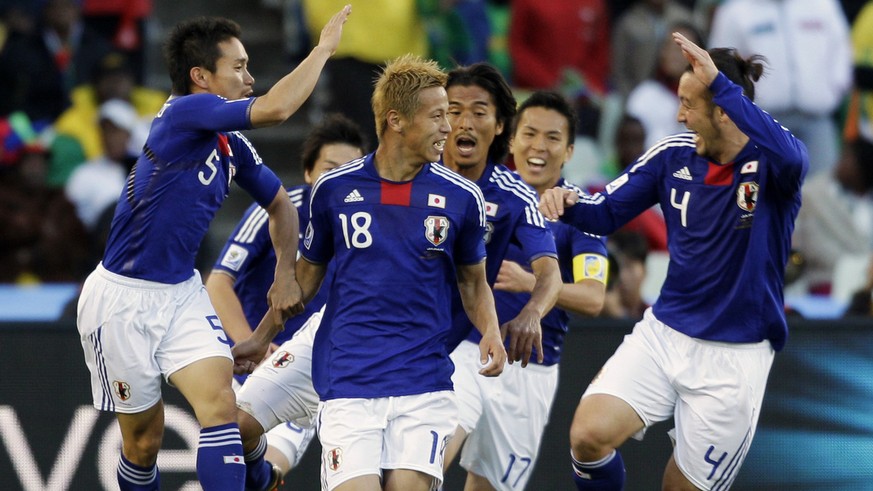 Japan&#039;s Keisuke Honda, center, celebrates with fellow team members Yuto Nagatomo, left, and Marcus Tulio Tanaka, right, after scoring the opening goal during the World Cup group E soccer match be ...