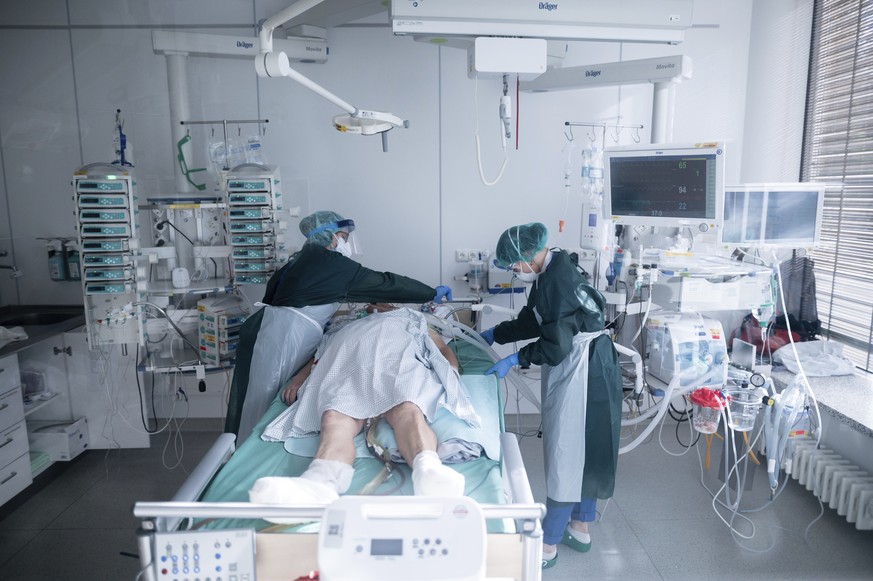Nursing staff in protective equipment cares for a corona patient in a hospital in Essen, Germany, Wednesday, Oct. 28, 2020. People with a new coronavirus infection are treated in the intensive care un ...