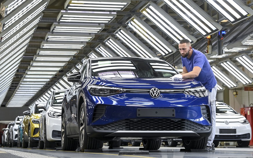 In this photo taken on Sept. 18, 2020, an employee puts finishing touches to a VW ID.4 Volkswagen at the Volkswagen plant in Zwickau, Germany. Volkswagen is unveiling a battery-powered SUV called the  ...