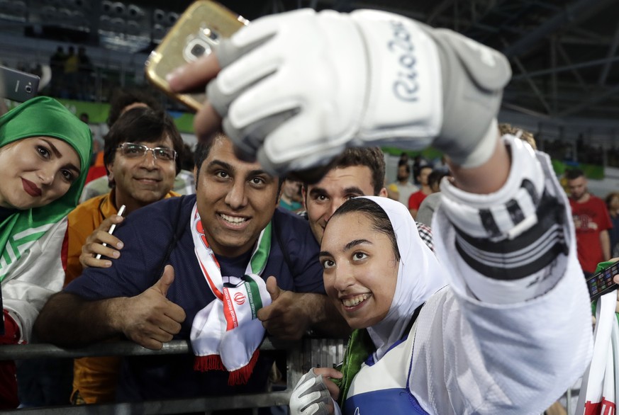 Kimia Alizadeh Zenoorin of Iran takes a selfie photo with spectators as she celebrates after winning the bronze medal in a women&#039;s Taekwondo 57-kgcompetition at the 2016 Summer Olympics in Rio de ...