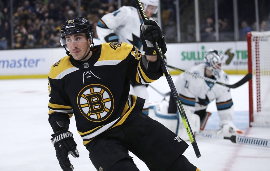 Boston Bruins left wing Brad Marchand, left, raises his stick after a goal against San Jose Sharks goaltender Martin Jones, right, during the second period of an NHL hockey game in Boston, Tuesday, Fe ...