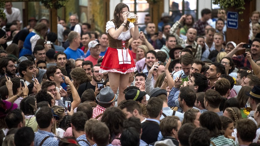 epaselect epa06208022 Visitors cheer inside the Hofbraeu tent during the opening of the 184rd edition of the traditional Oktoberfest beer and amusement festival in the German Bavaria state&#039;s capi ...