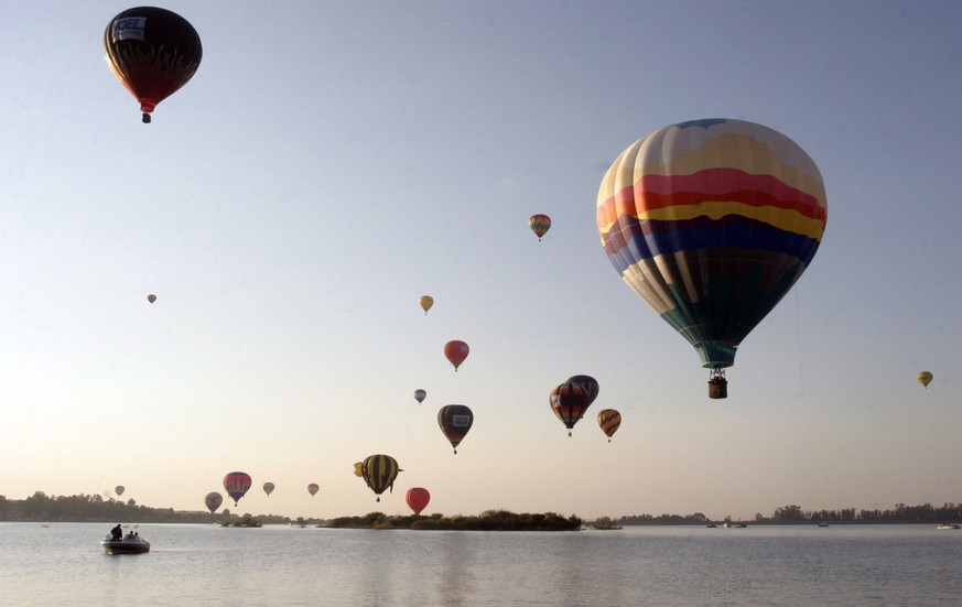 Hot air balloons take flight over the Palote reservoir in the city of Leon, Mexico during the last day of the Fifth International Hot Air Balloon Festival, Sunday, Dec. 3, 2006. (AP Photo/Mario Armas)