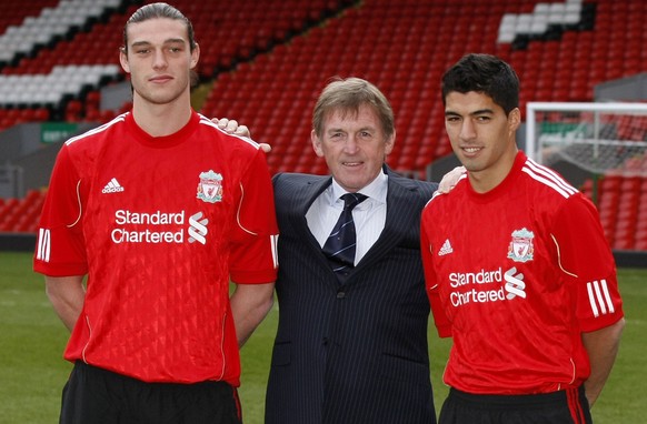 Liverpool manager Kenny Dalglish, center, poses for photos with new signings Andy Carroll, left, and Luis Suarez before a press conference at Anfield, Liverpool, England, Thursday Feb. 3, 2011. (AP Ph ...