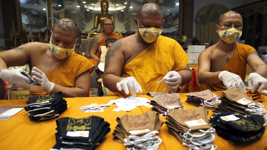 epa08329843 Thai Buddhist monks pack face masks inscribed with spiritual incantations at Wat Phai Lom in Nakhon Pathom province, Thailand, 29 March 2020. The face masks made by villagers are inscribed ...