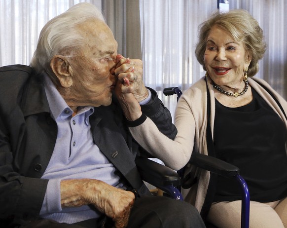 FILE - In this May 4, 2017, file photo, Kirk Douglas kisses his wife Anne&#039;s hand, in Los Angeles during a party celebrating his 100th birthday. Anne Douglas, the widow of Kirk Douglas and stepmot ...