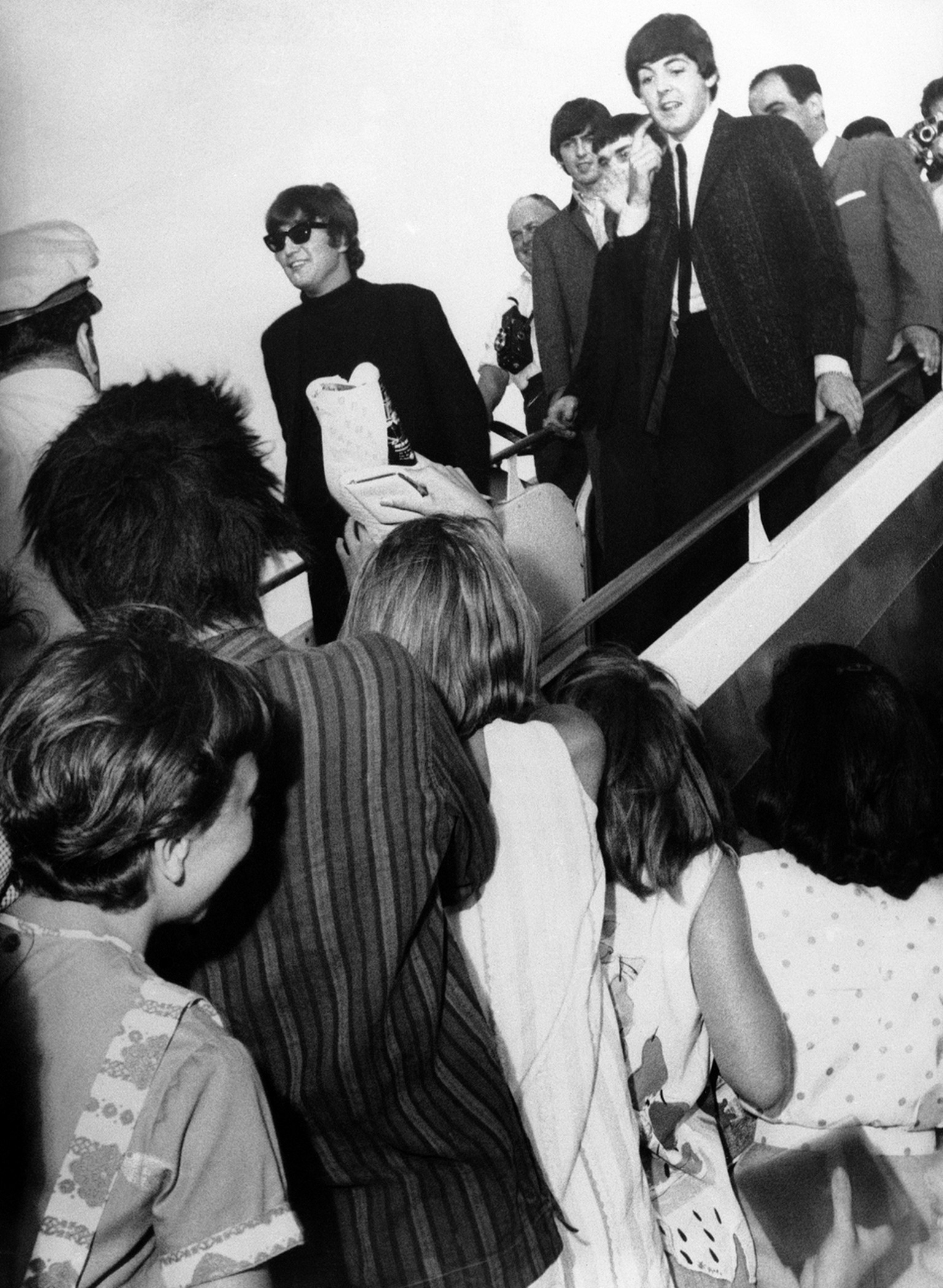 Looking a little surprised but very pleased at their wild reception at Beirut Airport in Lebanon, the Beatles pop group make a brief appearance on the steps of their jet airliner, on June 7, 1964, at  ...