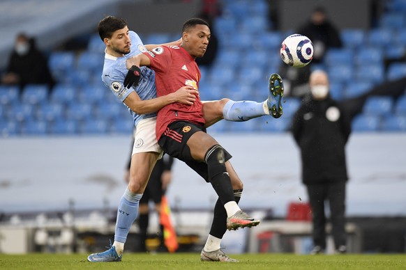 Manchester City&#039;s Ruben Dias, left, fights for the ball with Manchester United&#039;s Anthony Martial during the English Premier League soccer match between Manchester City and Manchester United  ...