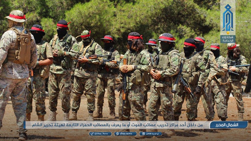 FILE - This Monday, Aug 20, 2018 photo provided by the al-Qaida-affiliated Ibaa News Network, shows fighters of the al-Qaida-linked coalition known as Hay&#039;at Tahrir al-Sham, Arabic for Levant Lib ...