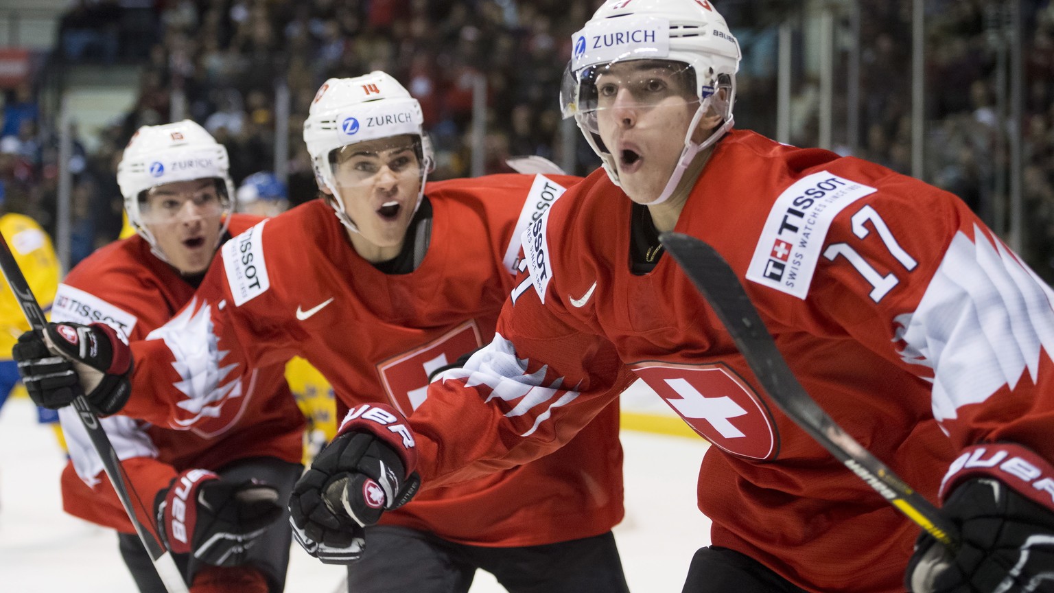 Switzerland&#039;s Luca Wyss, right, celebrates his goal past Sweden with teammates Sandro Schmid and Matthew Verboon during the second period of a world junior hockey championships game in Victoria,  ...