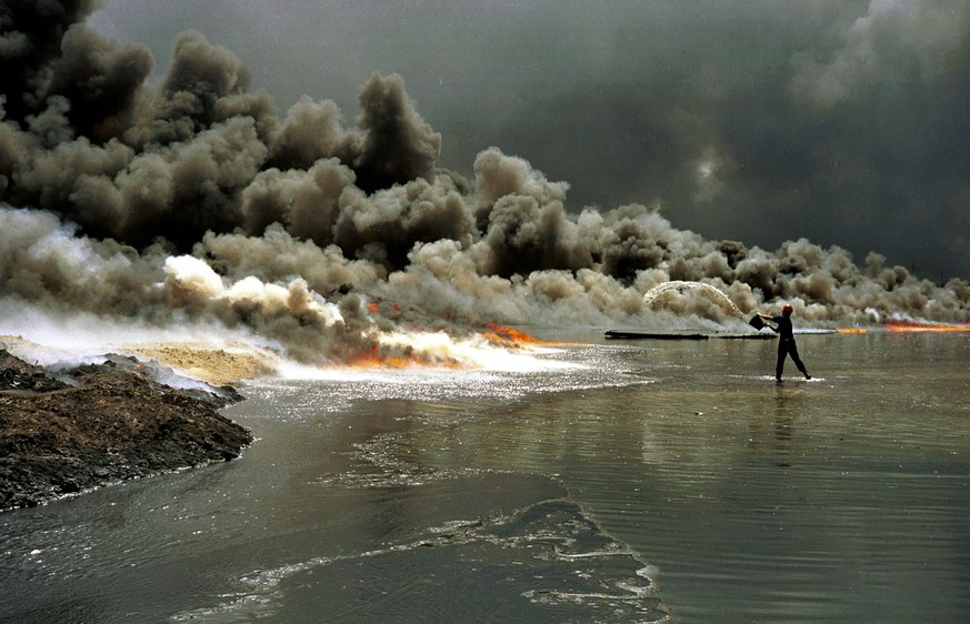 GREATER BURHAN OIL FIELD, KUWAIT - AUGUST 09: (.) An unidentified firefighter tries to extinguish an oil well fire August 9, 1991 at the Greater Burhan oil field in Kuwait. When the Gulf War ended in  ...