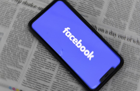 epa09020505 An illustration image shows a phone screen with the Facebook logo and Australian Newspapers at Parliament House in Canberra, Australia, 18 February 2021. Social media giant Facebook has mo ...