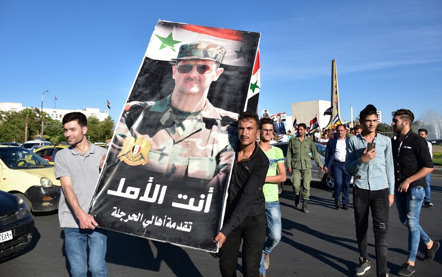 epa08479564 Thousands of Syrians are gathering at the Umayyad Square in Damascus, Syria, on 11 June 2020, in support of President Bashar Assad and to denounce the Caesar Act that is scheduled to be pu ...