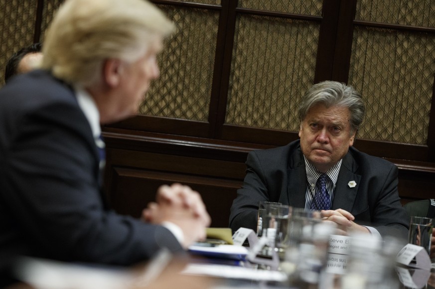 White House Chief Strategist Steve Bannon listens at right as President Donald Trump speaks during a meeting on cyber security in the Roosevelt Room of the White House in Washington, Tuesday, Jan. 31, ...