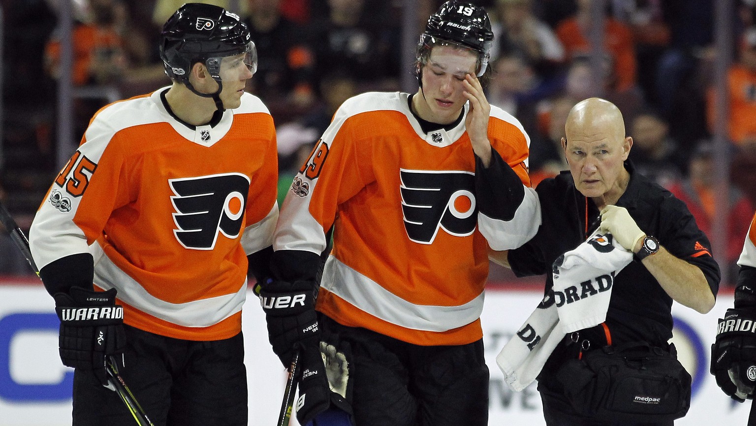 CORRECTS TO SAY PATRICK DID NOT RETURN TO THE GAME AFTER THE INJURY - Philadelphia Flyers&#039; Nolan Patrick, center, is helped of the ice by Jori Lehtera, left and a member of the training staff aft ...