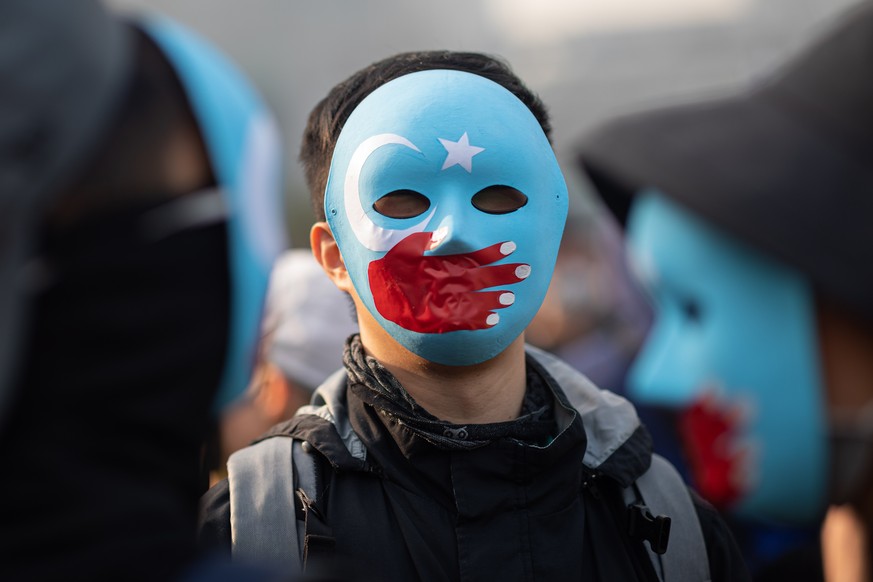 epa08086437 Protesters wear masks during rally in support of the Muslim Uyghurs of Xinjiang in Hong Kong, China, 22 December 2019. Participants expressed concerns that Hong Kong will soon face similar ...