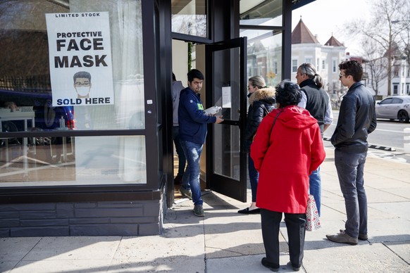 epa08275334 Customers line up outside a pop up shop offering hand sanitizer, rubber gloves and face masks in Washington, DC, USA, 06 March 2020. There are 245 confirmed cases with 14 deaths in the US  ...