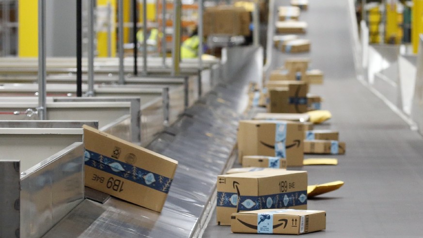 FILE - In this Dec. 17, 2019, file photo, Amazon packages move along a conveyor at an Amazon warehouse facility in Goodyear, Ariz. Amazon