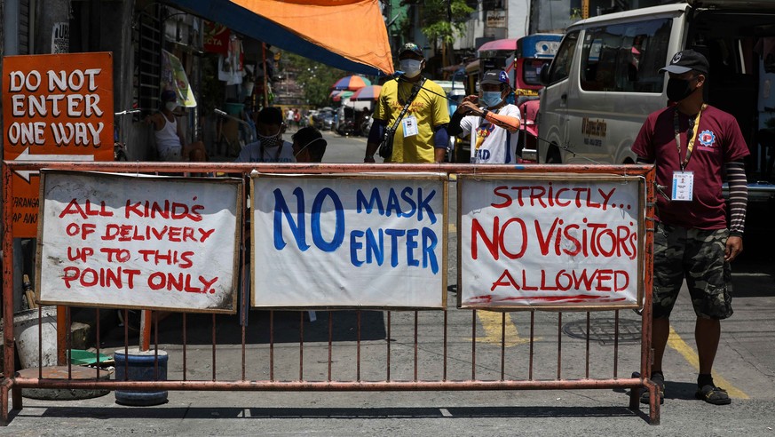 epa08340119 Local village volunteers stand guard at a checkpoint of a residential area in Manila, Philippines, 03 April 2020. The Philippines announced on 02 April that people residing on Luzon island ...