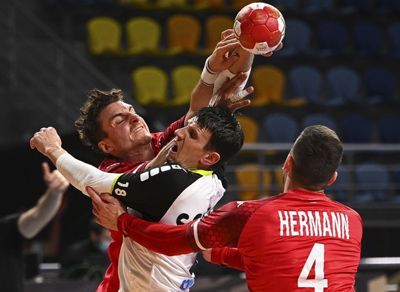 epa08937749 Switzerland&#039;s Andy Schmid (C) in action against Austria&#039;s Maximilian Hermann (R) during the match between Austria and Switzerland at the 27th Men&#039;s Handball World Championsh ...