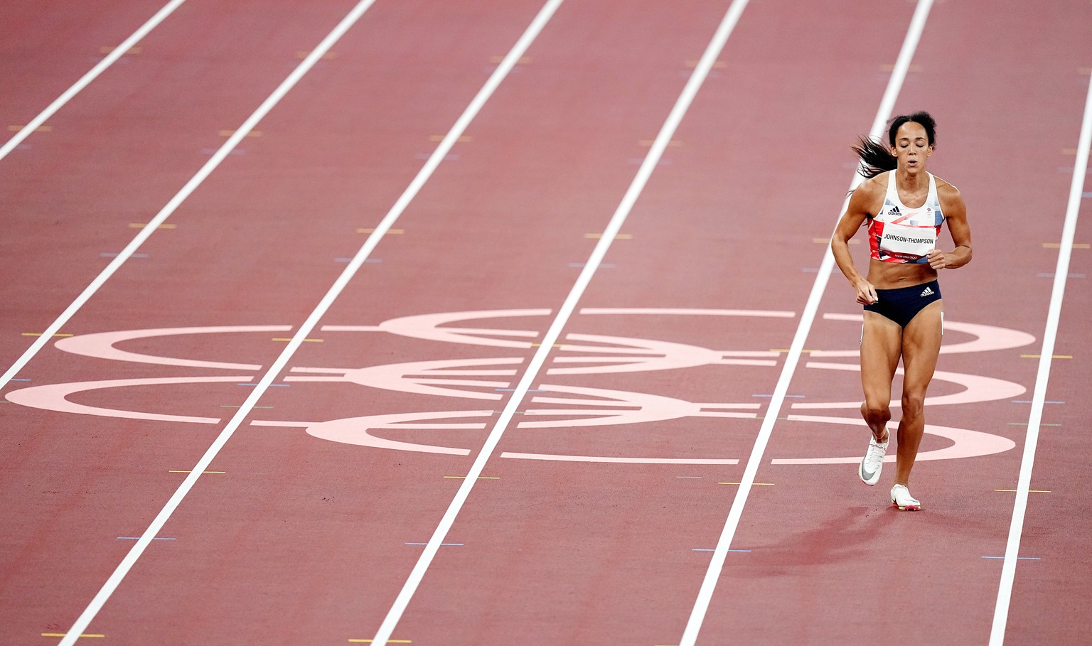 epa09394639 Katarina Johnson-Thompson of Great Britain continues her run after temporarily sitting on the track during her race in the 200m of the Heptathlon during the Athletics events of the Tokyo 2 ...