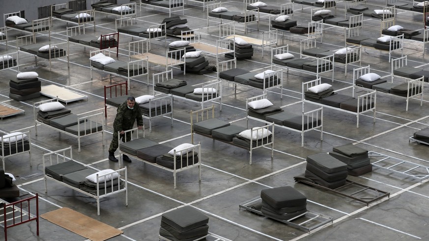 A Serbian soldier inspects beds for treatment of possible COVID-19 infected patients inside of the Belgrade Fair, Serbia, Tuesday, March 24, 2020. For most people, the new coronavirus causes only mild ...